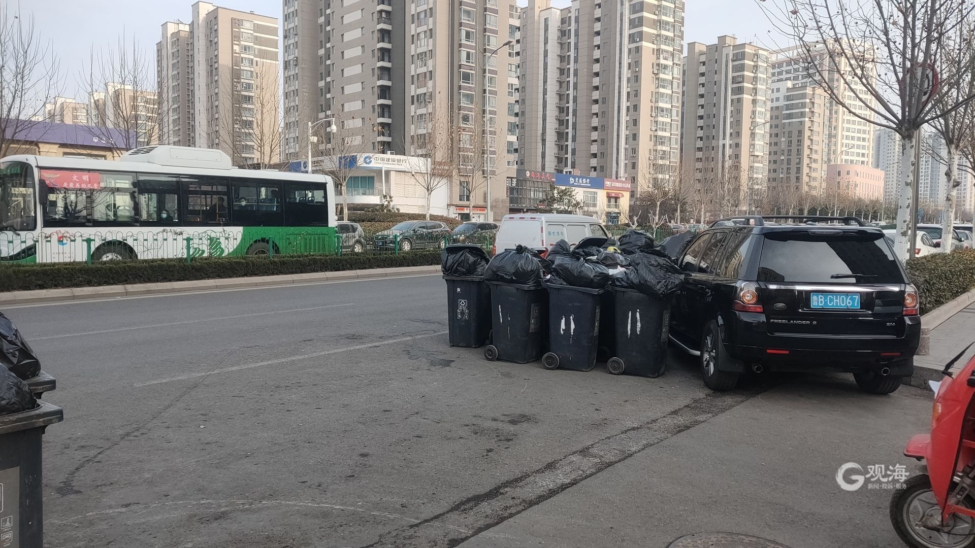 记者在现场垃圾桶堆积成群落马路旁行车过路难